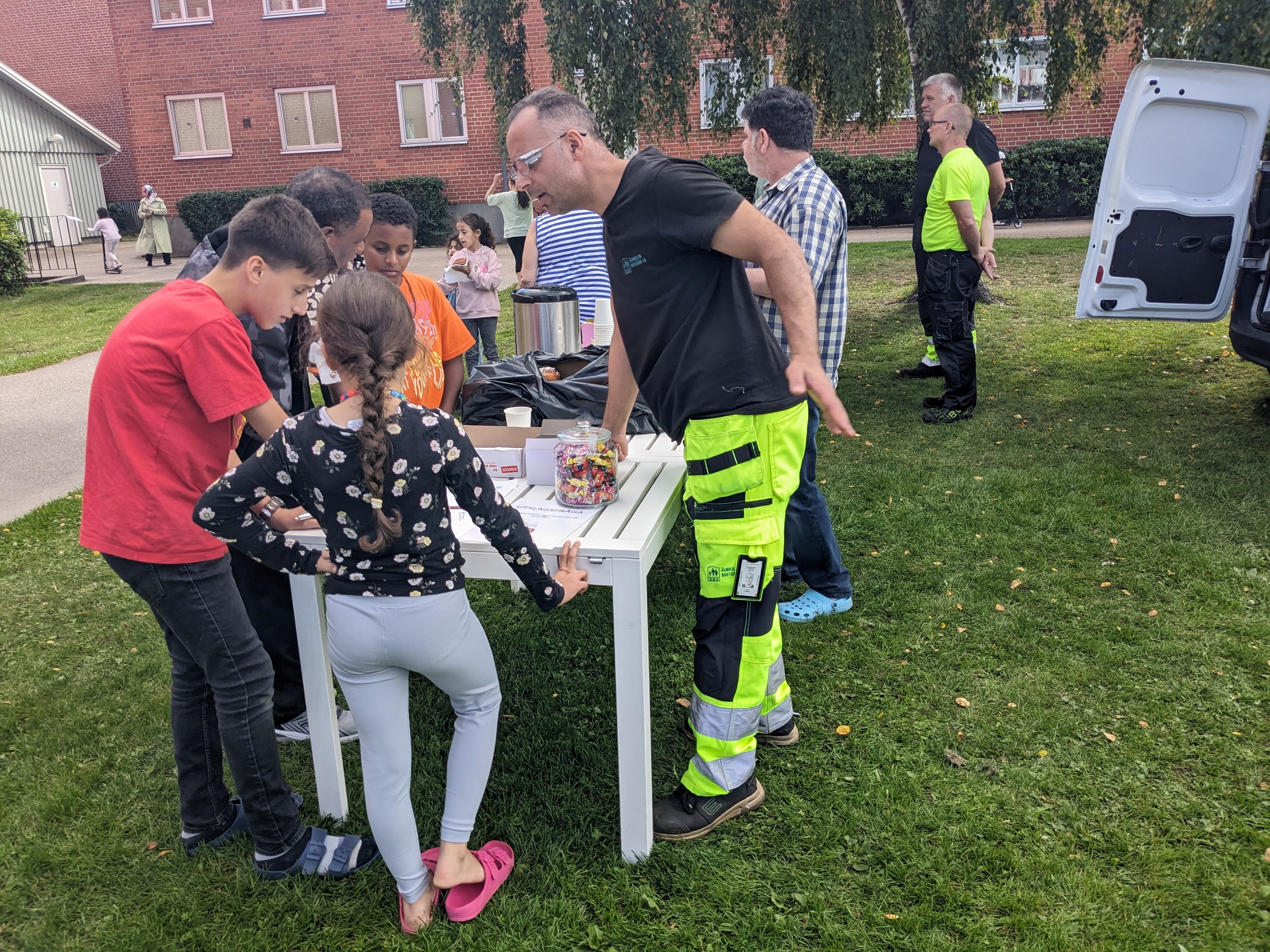 Flera människor samlade runt ett bord på en gårdsträff