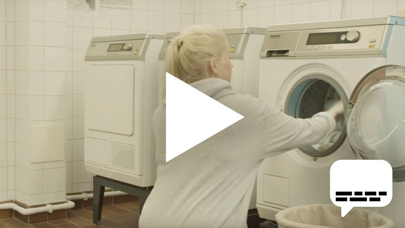 En person som fyller en tvättmaskin med tvätt